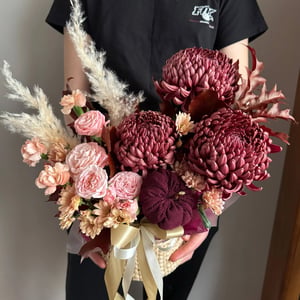 Arreglo floral en cesta con una pequeña calabaza.