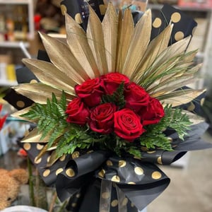 A bouquet of roses with a golden fan