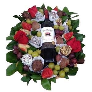 Arrangement von Erdbeeren, Trauben, Wein und Rose