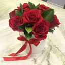 Rosas rojas con vegetación en una caja de sombreros