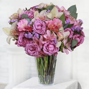 Violetter Blumenstrauß: weiße Rosen, Cymbidiums und Alstroemerien