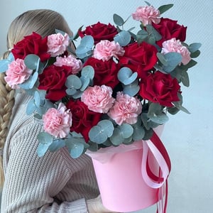 Hat box with flowers 'An arrangement of lace-like carnations and roses.'