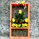 Blumenarrangement in einem Rahmen mit Flaschen