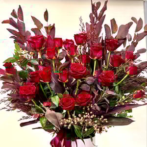 A bouquet of 24 red roses with leaves.