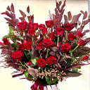A bouquet of 24 red roses with leaves.