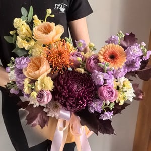 Blumenarrangement 'Chrysanthemen, Rosen und Germini in einem Kürbis'