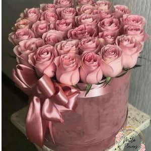 Dans la boîte, il y a des roses roses