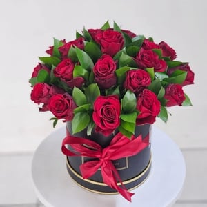 Blumenbox 'Rote Rosen in einer schwarzen Box mit Grünpflanzen'