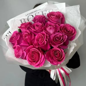 Blumenstrauß 'Ein leuchtendes Bouquet roter Himbeerrosen, verpackt.'